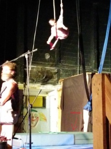 A girl is doing trapeze with a mattress below